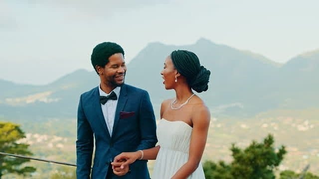 Bride and groom walking hand in hand with mountains behind them