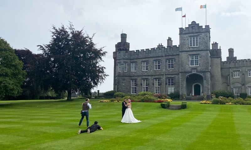 Videographers filming a bride and groom on the lawn in front of Luttrellstown Castle