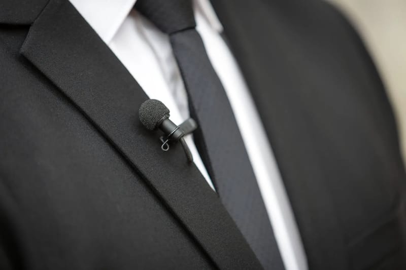 A lavalier microphone clipped to a groom's suit jacket
