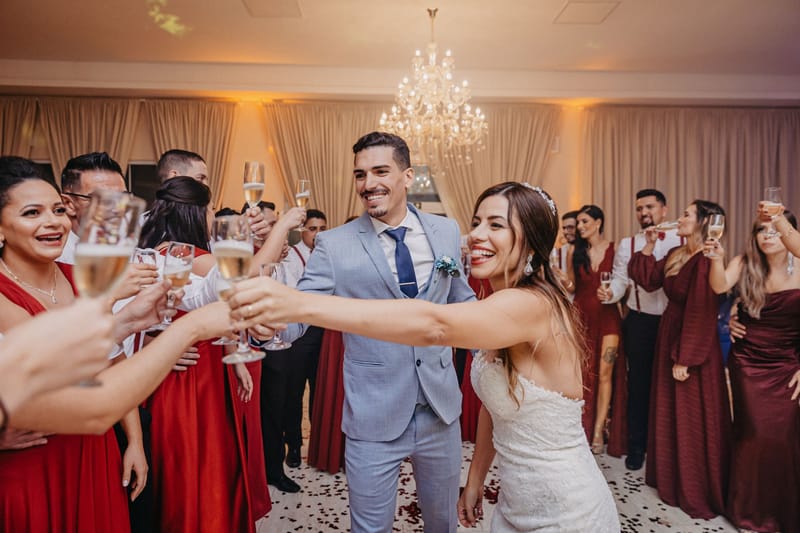 Wedding guests celebrating together under the chandeliers of a reception room