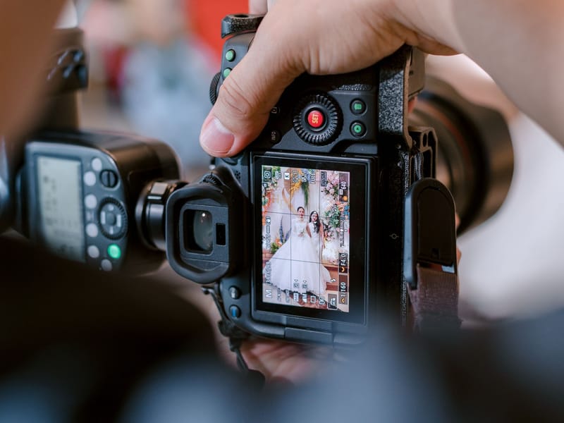 A wedding photographer checking a shot of the bride on the back of the camera